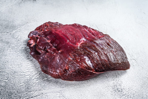 Venison raw deer meat on a table. White background. Top view.